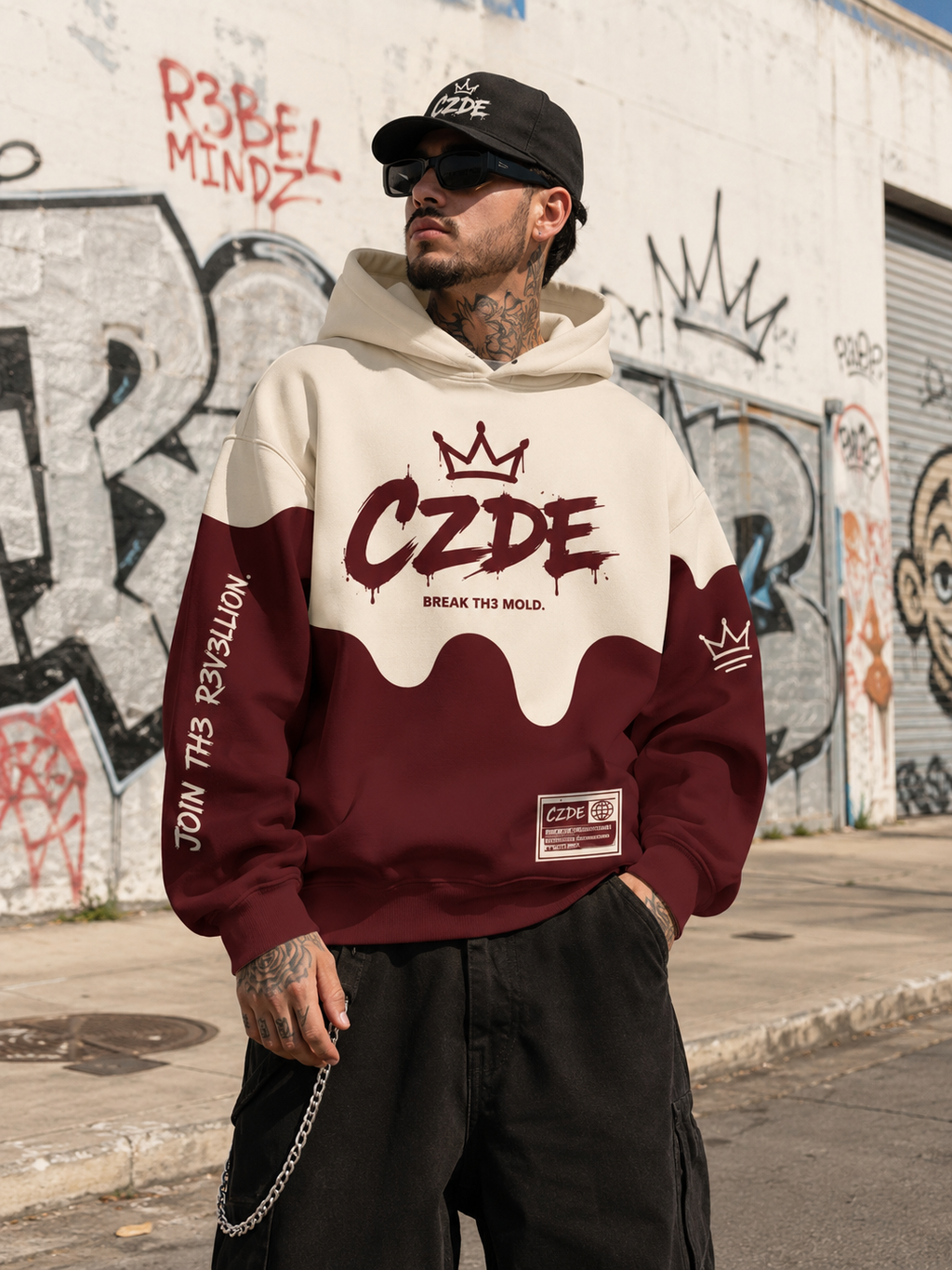 Male model wearing CZDE Burgundy Drip Hoodie – front view, Los Angeles graffiti wall street editorial with REBEL MINDZ background