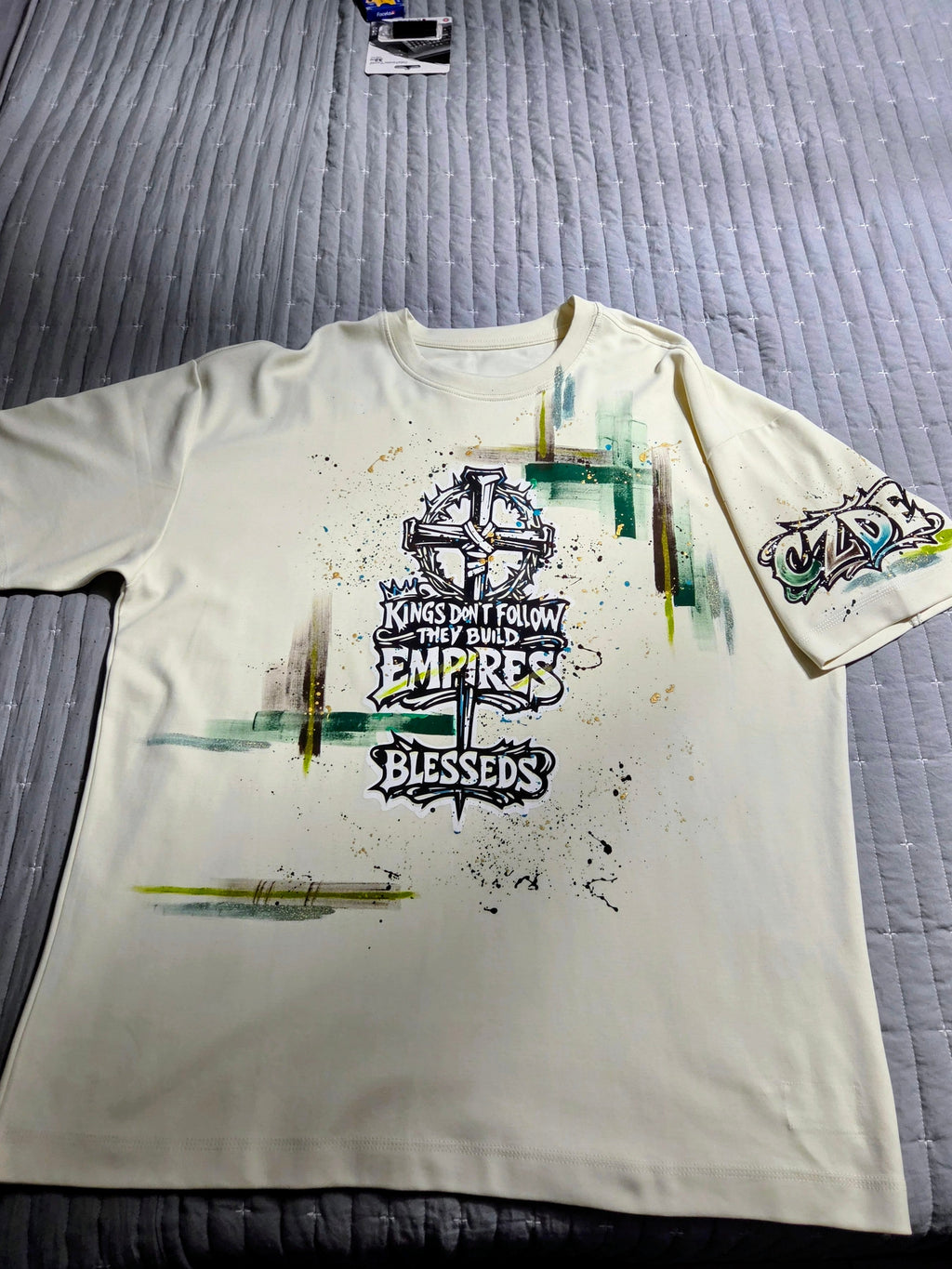 CZDE Build Empires Graffiti Tee – Full front view with cross graphic and paint splatter