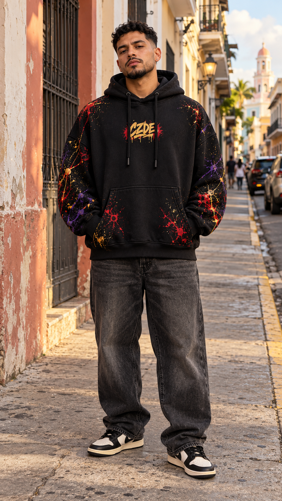 Black oversized hoodie with purple red speckled sleeves and small chest graphic